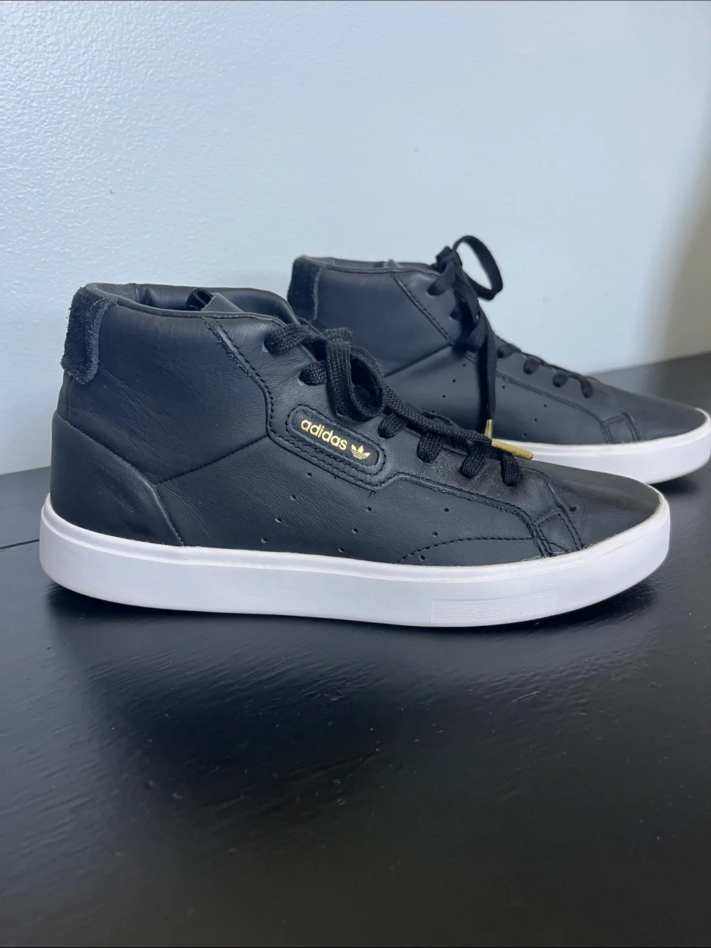 Adidas W/7.5 Black High-Top Sneakers/ white sole and gold logo.